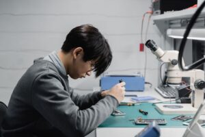 Techniker repariert ein Smartphone unter einem Mikroskop