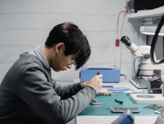 Techniker repariert ein Smartphone unter einem Mikroskop